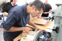 Renner Academy student training on piano action hammer boring jig..